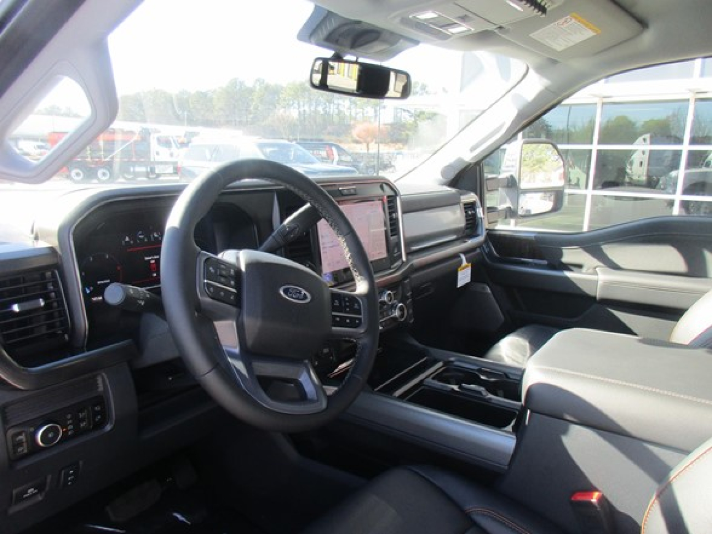 Interior of a 2026 Ford F-350 cab showing steering wheel, dashboard, and center console with touchscreen, driver seat, and passenger seat.