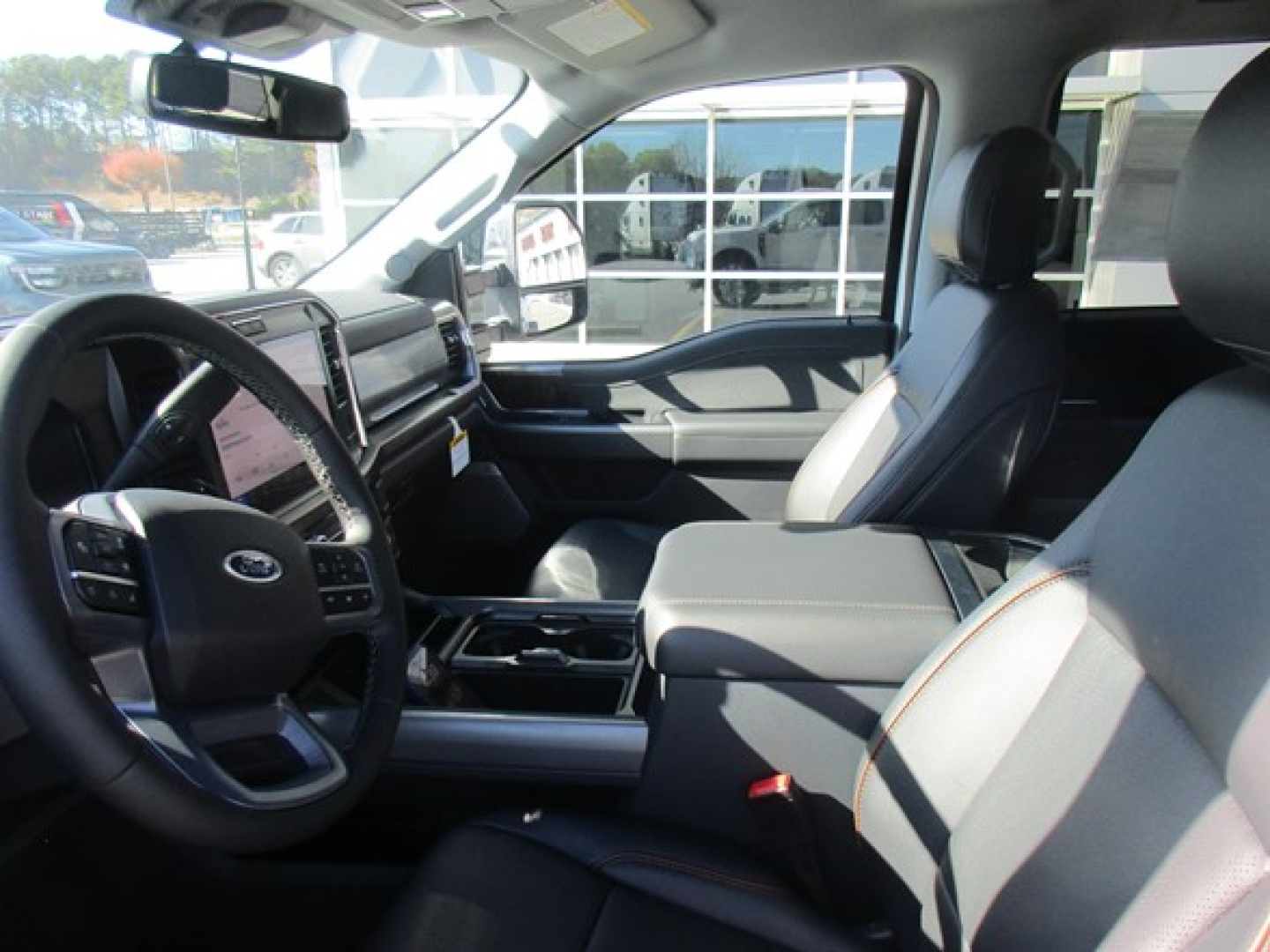 Ford F-350 interior showing driver and front passenger seats, steering wheel, center console, and dashboard in a pickup truck.