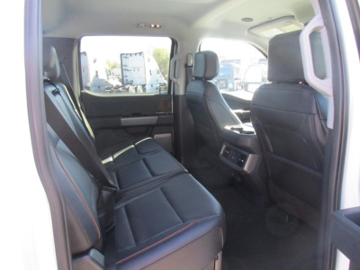 Ford F-350 interior rear seats view showing black leather seats with orange stitching and rear air vents.