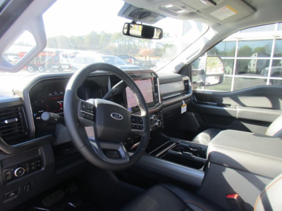 Interior of a 2026 Ford F-350 cab showing steering wheel, dashboard, and center console with touchscreen, driver seat, and passenger seat.