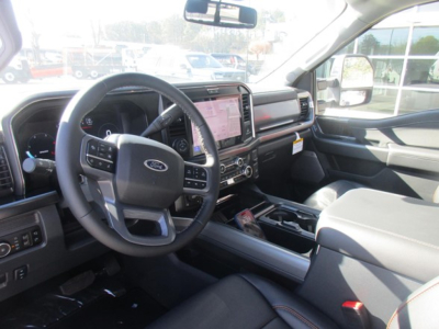 Ford F-350 interior front cabin with steering wheel, large touchscreen infotainment, center console, and driver seat; dashboard displays and controls visible.