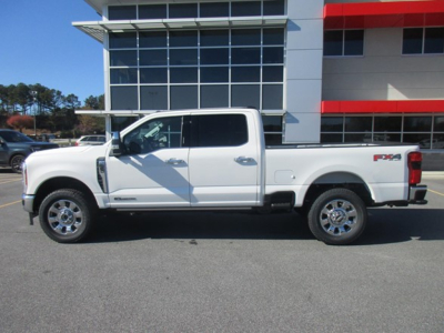 Ford F-350 pickup truck side view showing extended cab, white color, chrome wheels, long bed, RSX badge on rear quarter panel.