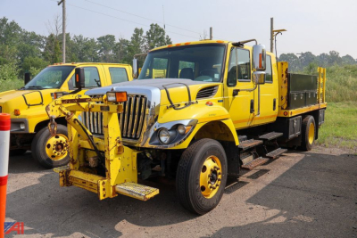 International WorkStar 7300 crew cab stake truck with plow hitch in yellow, front view, two-tone yellow body, stake bed, plow mount, daytime exterior