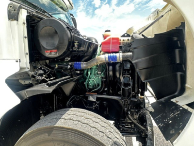 Volvo VHD engine bay with visible air intake, coolant reservoir, hoses, and front suspension components.