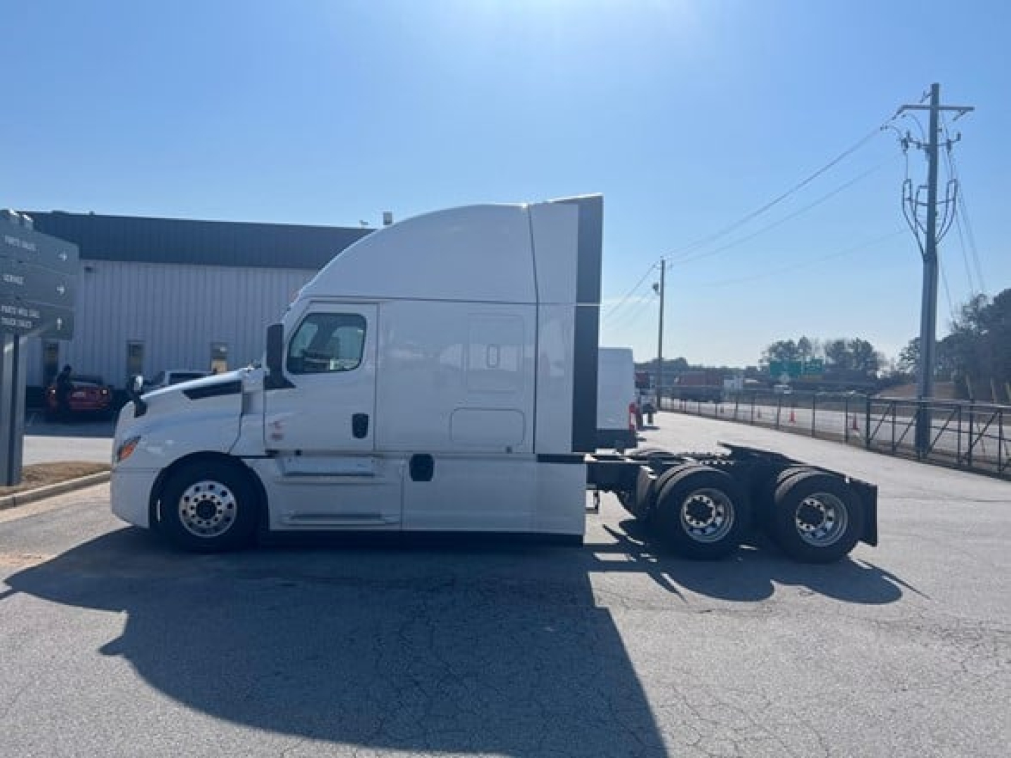 Conventional sleeper truck side view showing Freightliner Cascadia cab with aerodynamic roof, front wheel, and rear dual axles.