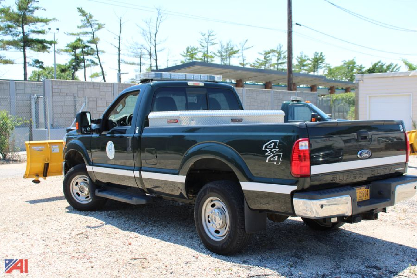 Ford F-250 Super Duty pickup with plow, 4x4 badge, dual rear wheels, in a lot.