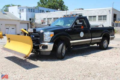 Ford F-250 Super Duty pickup with plow showing front view and service sticker on door.