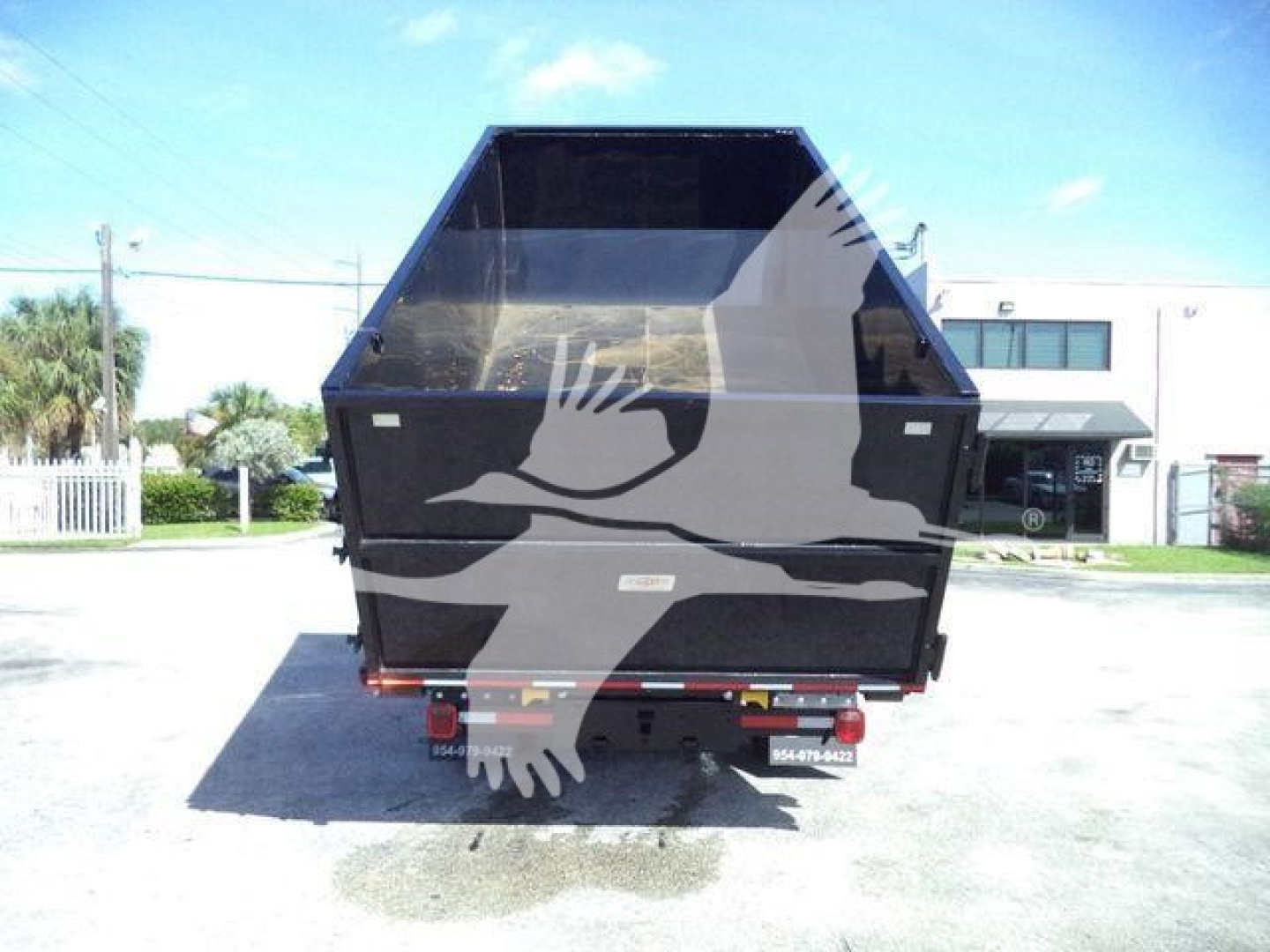 Chevrolet Silverado 6500HD dump bed shown from rear with hydraulic liftgate and roll-off bed in black, stock number visible