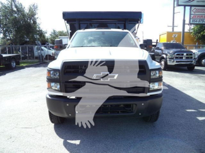 Front view of a 2023 Chevrolet Silverado 6500HD dump truck showing Chevy grille, headlights, and large front bumper.
