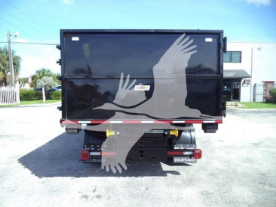 Truck rear view showing black dump body with white graphic of two hand silhouettes and safety reflective strip.