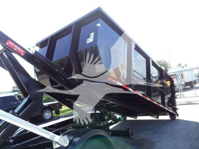 Truck bed with a folded roll-off container on a Chevrolet Silverado 6500HD; visible labels include 'NO FORKS' on a red arm and various hydraulic components under the container.