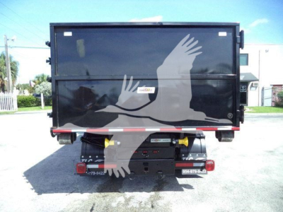Truck bed showing rear view of a 2023 Chevrolet Silverado 6500HD roll-off truck with black body and graphic eagle design.