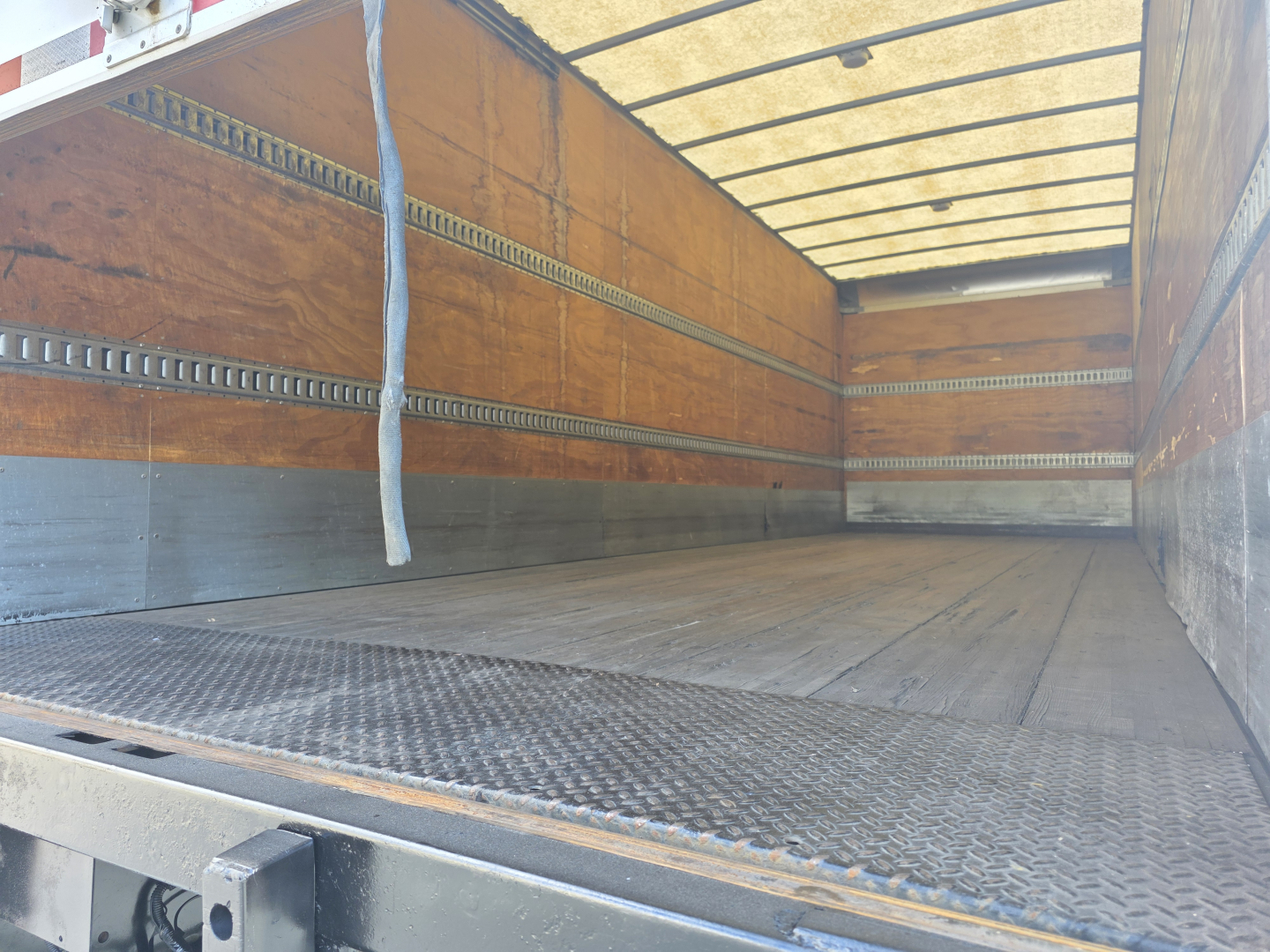 Peterbilt 337 truck bed interior showing empty cargo area with wooden sidewalls and metal brackets; no visible text or labels.