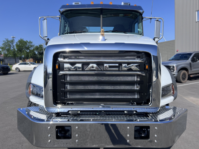 Front view of a white 2026 Mack GR64B cab and chassis showing the large black grille with 'MACK' emblem and chrome bumper.