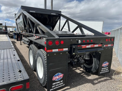 Dump trailer showing Versa Vale with black frame and multi-axle rear, Utility logos, and rear bumper with lights.