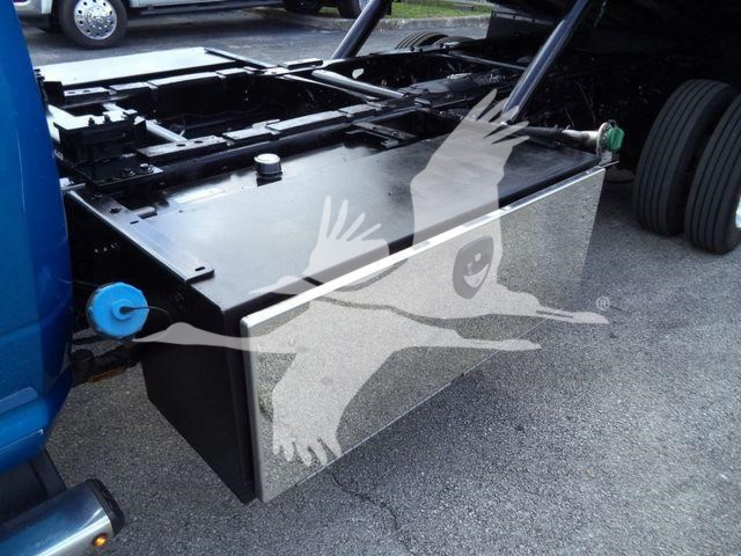 Ram 5500 rollback truck fuel tank/auxiliary tank mounted under truck bed showing metal rectangular tank with black cap and mounting bracket.