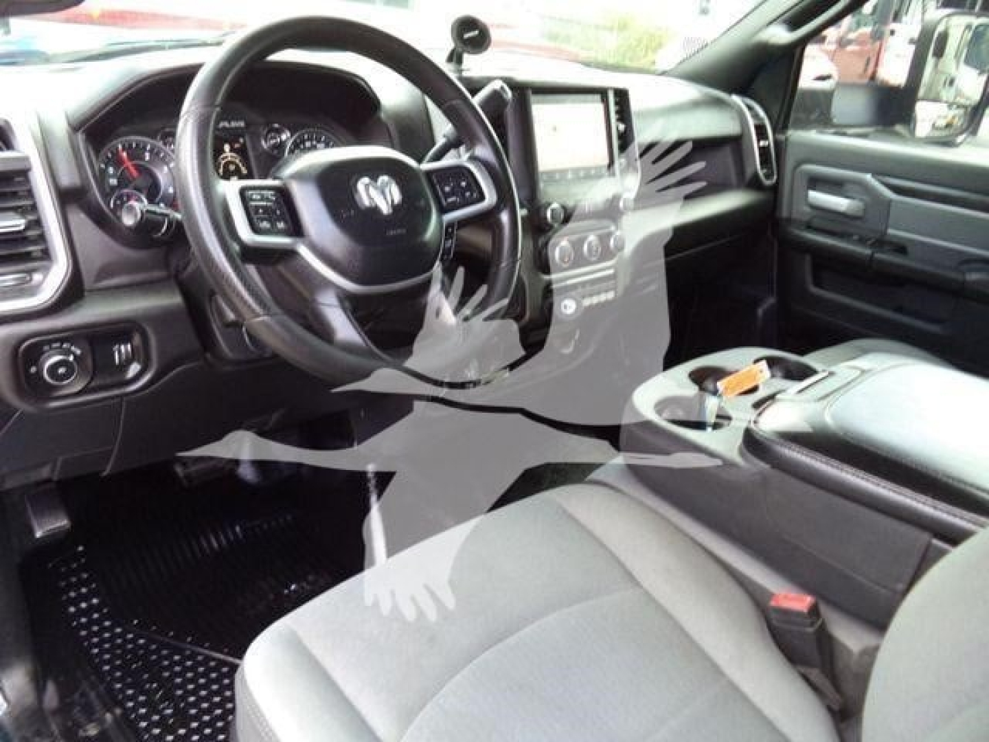 Ram 5500 interior showing steering wheel with Ram logo, center touchscreen, dashboard controls, and front seats in a pickup truck cab.