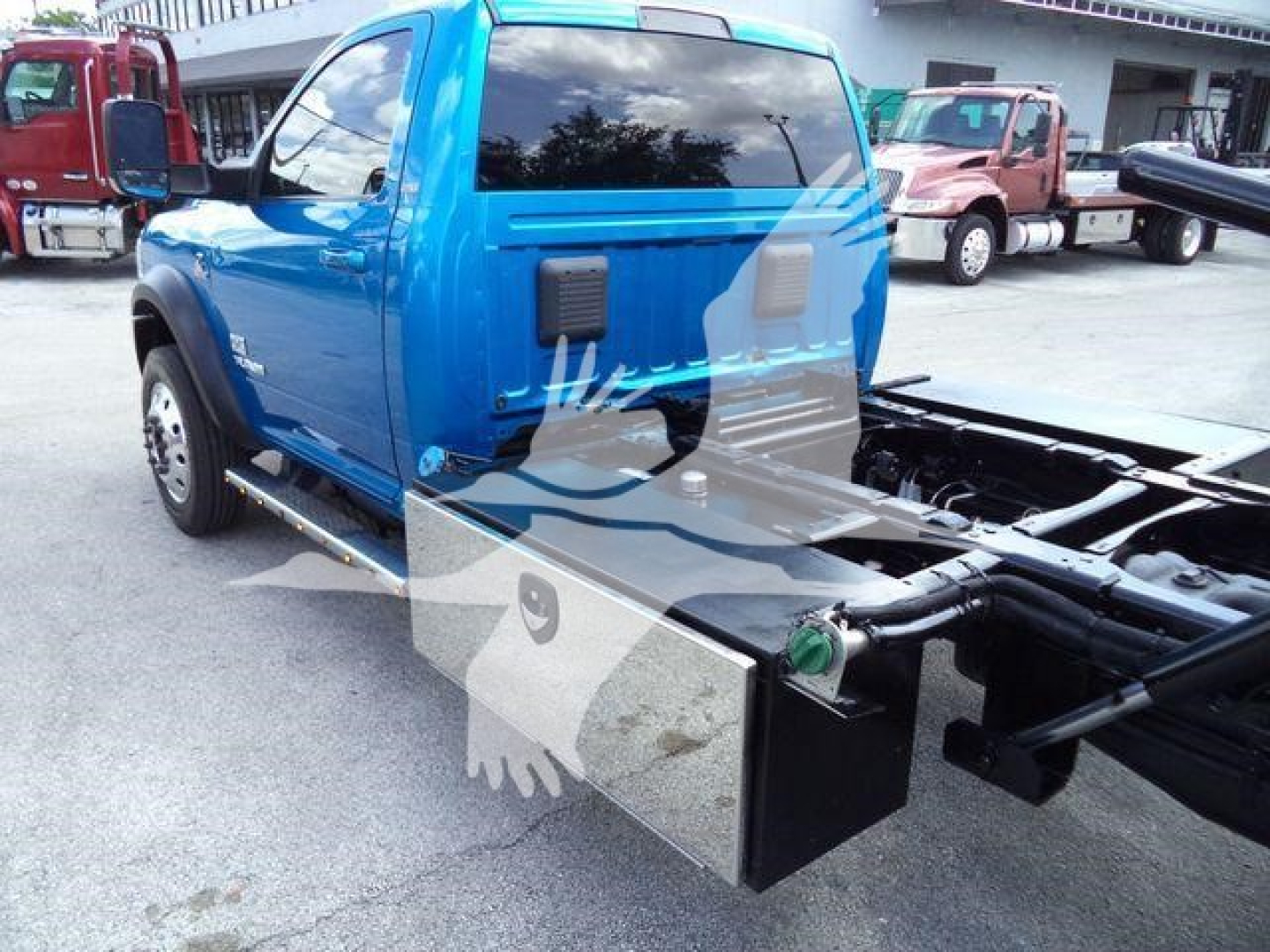 Blue 2022 Ram 5500 SLT cab and chassis showing side view with aluminum toolbox mounted near rear, rollout bed connectors visible.