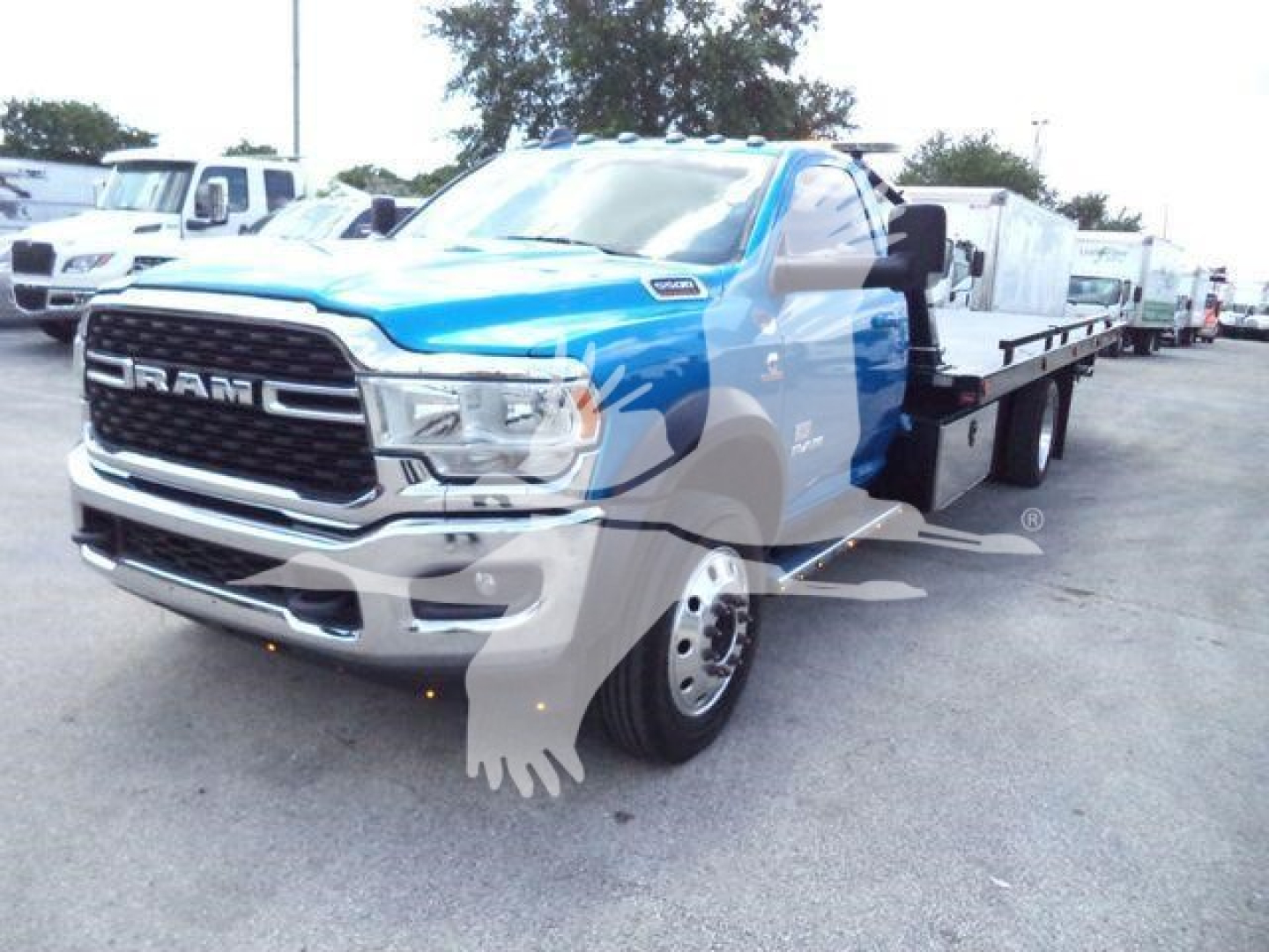 Ram truck 5500 SLT rollback w/ flatbed showing Ram grille and blue cab.