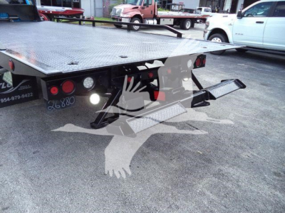Ram 5500 rollback tow truck flatbed rear view showing platform and hitch assembly with taillights.