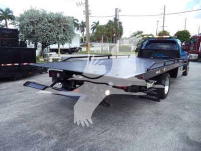 Ram 5500 rollback tow truck flatbed rear view showing loading ramp and dual rear wheels.