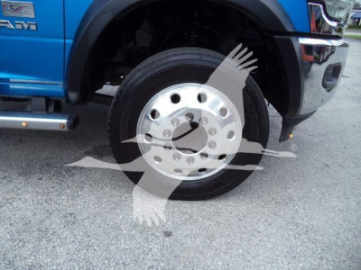Truck front wheel area showing steel wheel and front fender of a blue Ram 5500 SLT with chrome step bar.