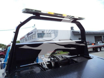 Ram 5500 rollback truck bed area showing heavy-duty diamond plate surface and hydraulic winch with rollbar.