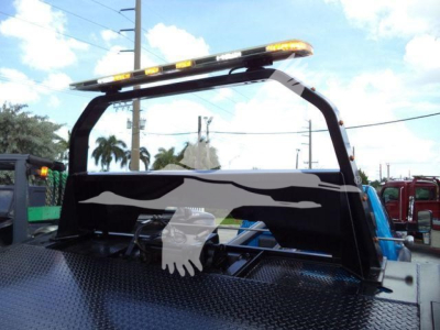Ram 5500 rollback truck equipment rack with black panel and decorative flame graphics and a white hand logo, cab visible in background.