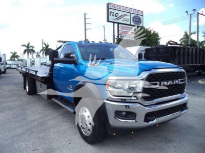 Ram 5500 rollback truck in blue front three-quarters view showing DODGE RAM grille and work-bed with tow hitch.