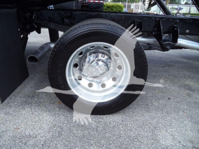 Ram 5500 wheel and suspension undercarriage view showing front tire and chrome hubcap with wheel well and frame components.