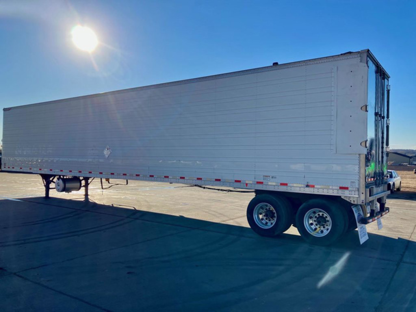 Great Dane reefer trailer with white exterior, dual rear axles, side view showing refrigerated trailer.