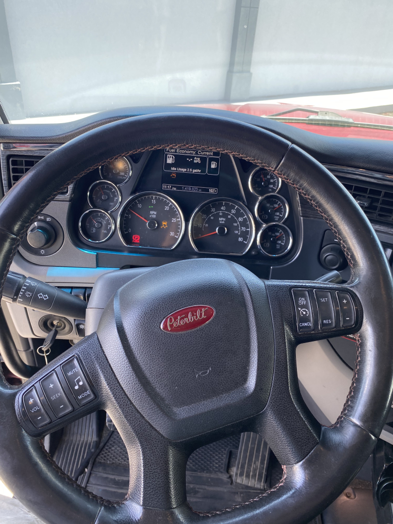 Peterbilt 567 dashboard and steering wheel view in a used conventional sleeper truck showing gauges and controls.
