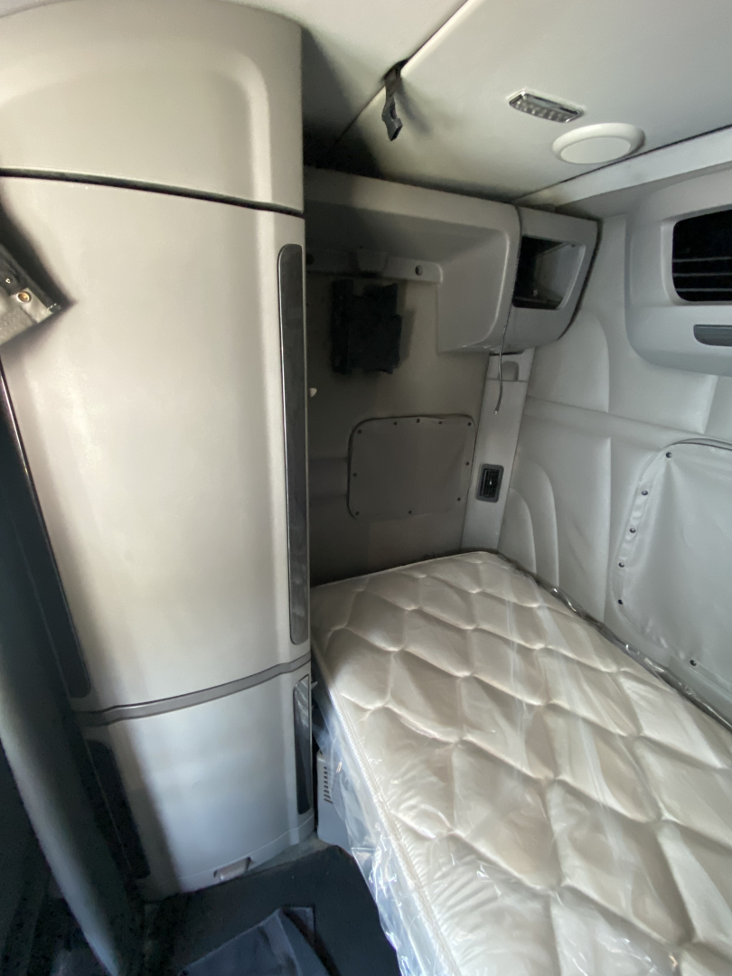 Peterbilt 567 truck sleeper cab interior showing leather-like quilted sleeper mattress and side panels.