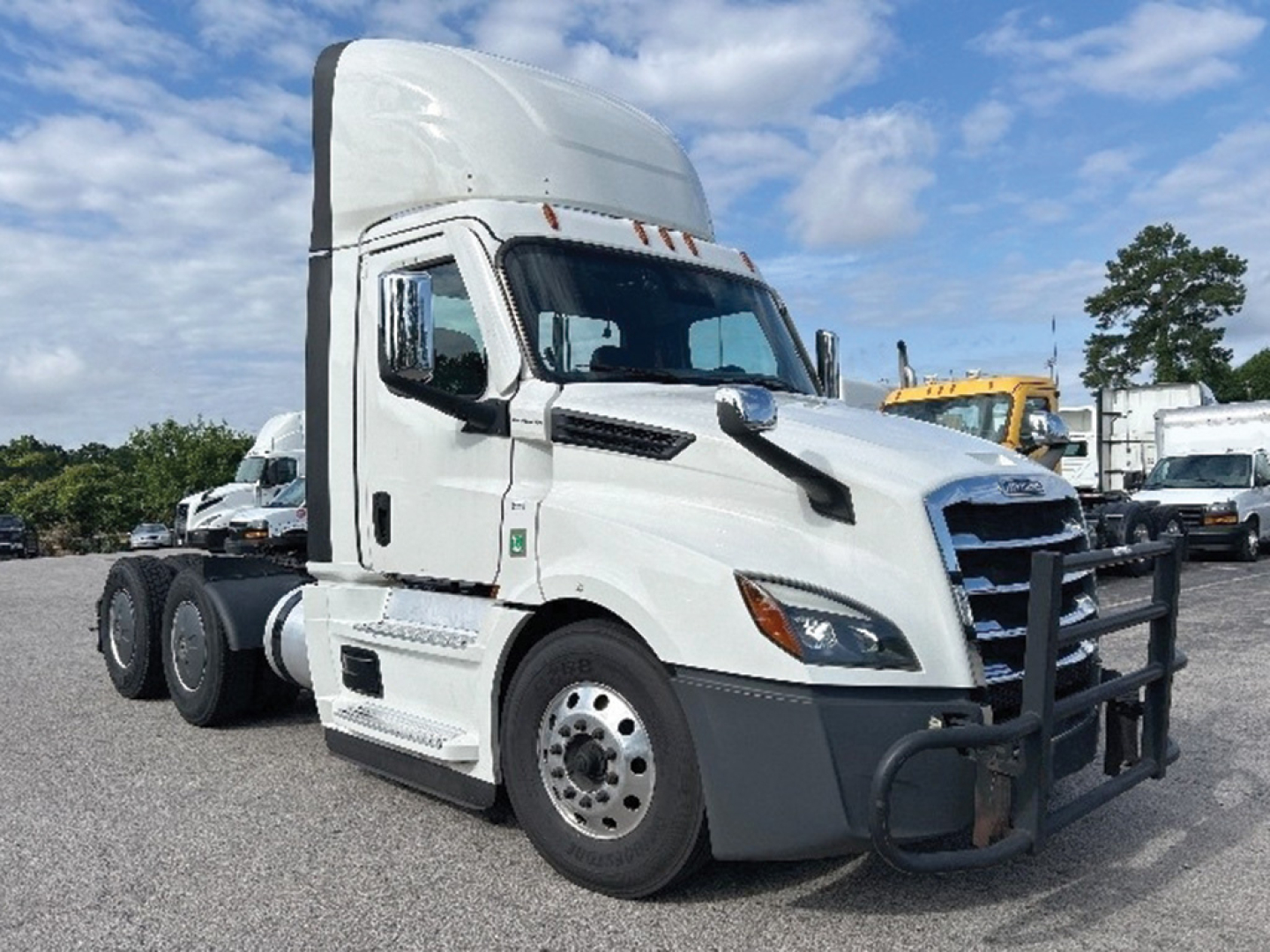 Truck cab of a 2020 Freightliner Cascadia126 conventional daycab showing side view with sleeper, chrome grille, and bumper guard.