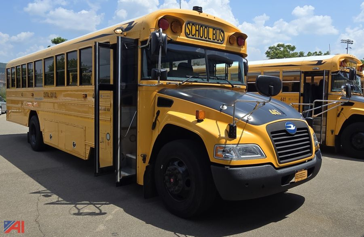 2018 Blue Bird Vision school bus side view showing front grade school bus with yellow body and black grille, operating doors open
