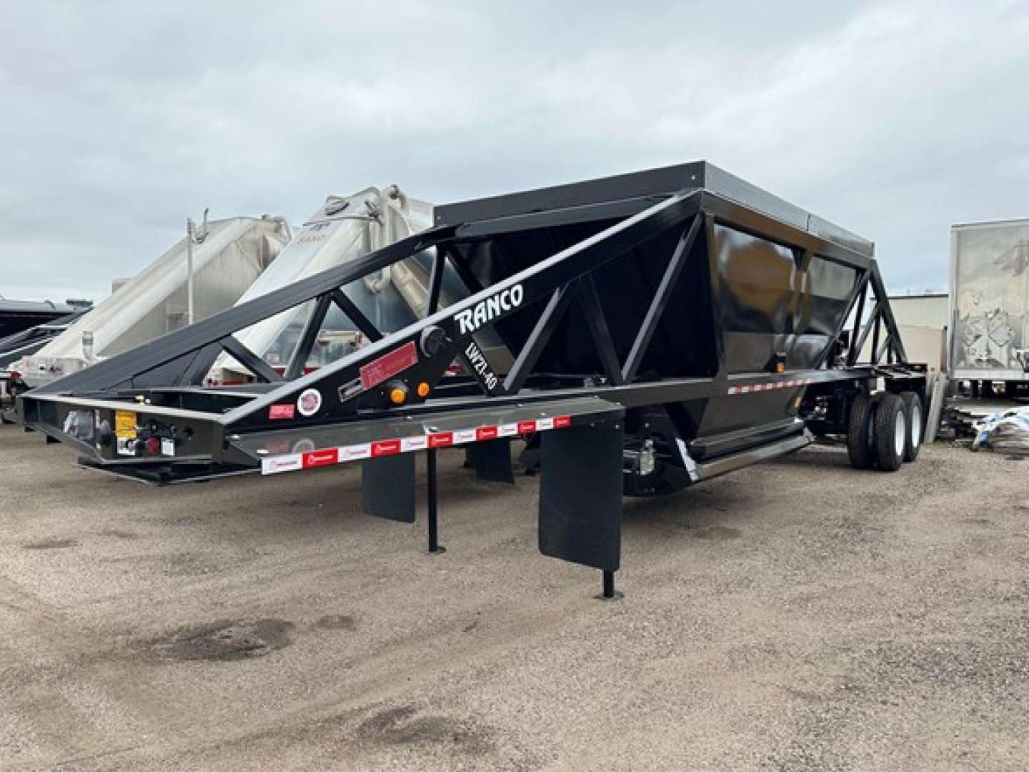 Ranco LW21-40 dump trailer with triangular frame, black color, with 'RANCO' branding on the side and front nose. Stand-alone tongue with hitch and support legs visible.