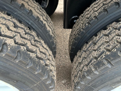 LW21-40 dump trailer wheels and dual tires, dirt/grime on treads and sidewalls visible.