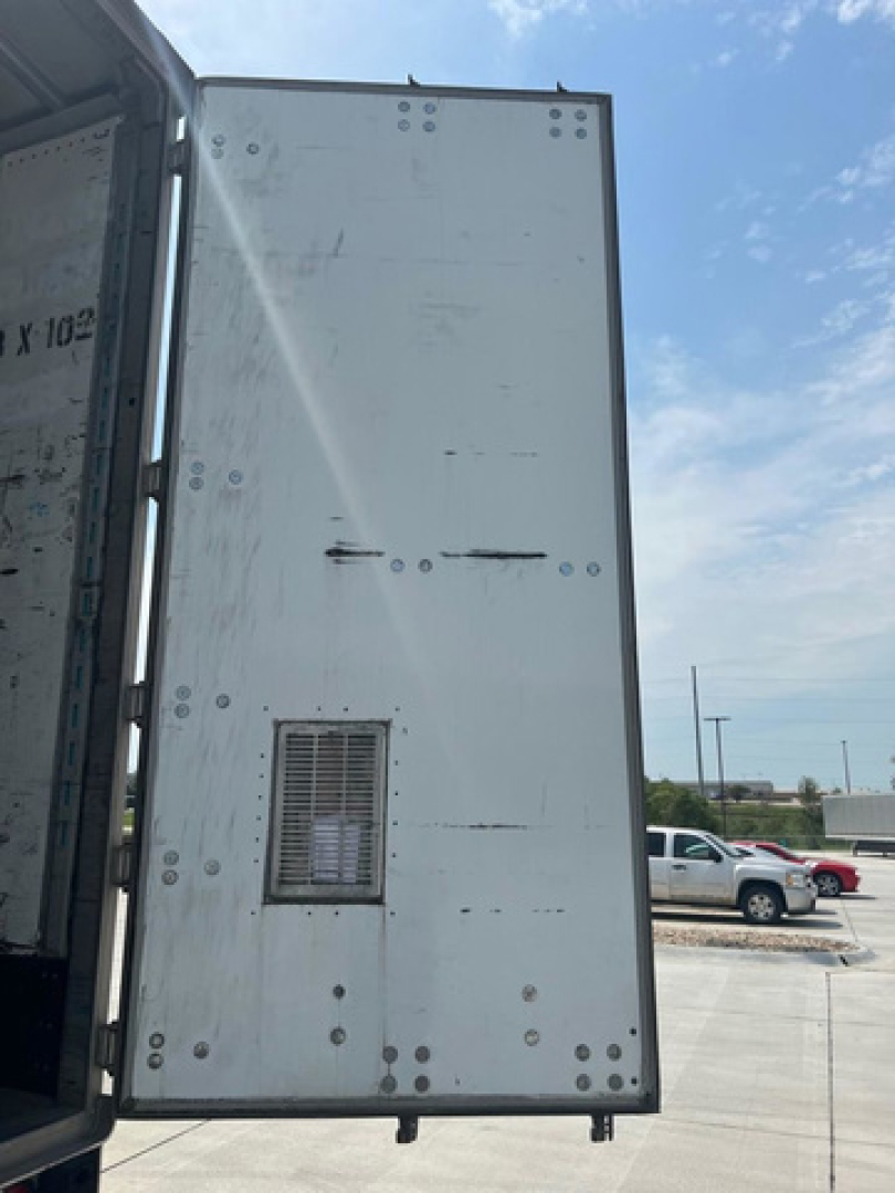 Back interior of a 2012 utility van trailer side door panel with small vent and rivets visible.