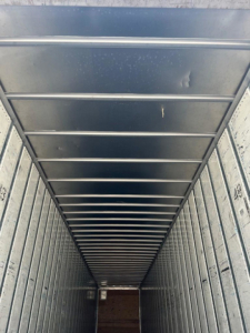 Interior of a utility van trailer showing metal sidewalls and ceiling ribs