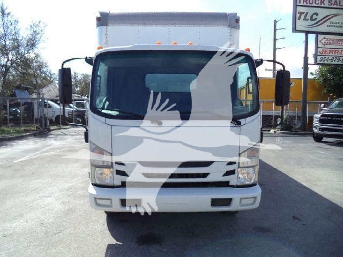 Isuzu NPR/box truck front view showing cab with windshield, headlights, and bumper. STOCK 210707FM. White exterior.
