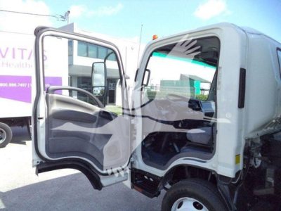 Isuzu NPR or NRR box truck cab interior with driver door open, showing steering wheel and dashboard.