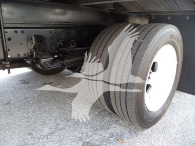 Isuzu NPR truck rear underbody showing dual rear axle and tires with white rims, suspension components, and undercarriage frame.