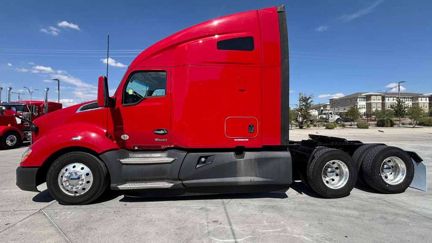Kenworth T680 truck side profile showing red cab and rear axles with dual rear wheels.