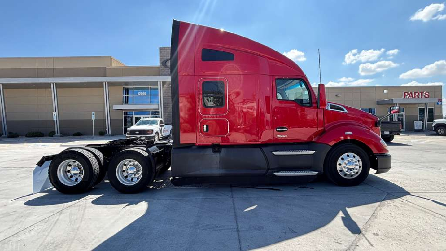 Kenworth T680 tractor in red side view showing cab and dual rear axles with chrome wheels.