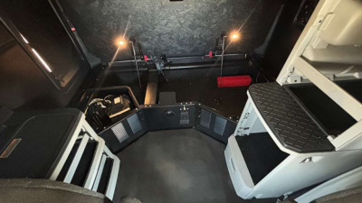 Kenworth T680 truck cab interior showing dashboard area and sleeper space with storage compartments.