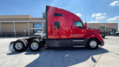 Kenworth T680 tractor in red side view showing cab and dual rear axles with chrome wheels.