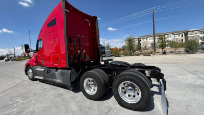 Kenworth T680 side view showing dual rear axles and red sleeper cab, no visible text on side; shows stance and wheels.