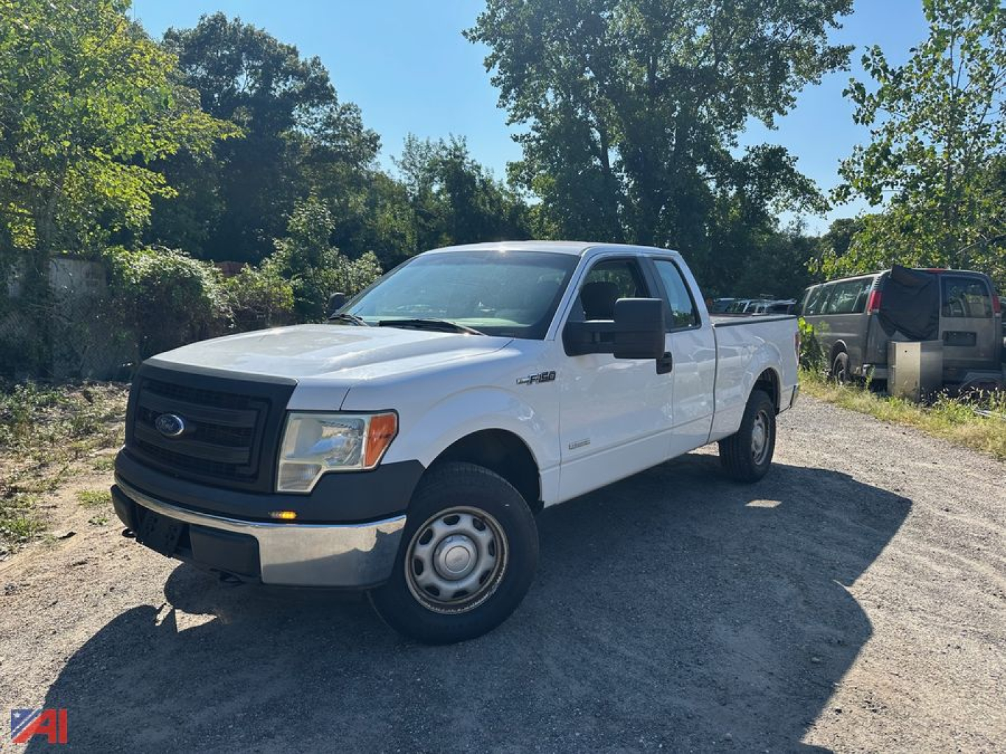 White 2014 Ford F-150 extended cab pickup truck parked on dirt lot, showing side and front view.