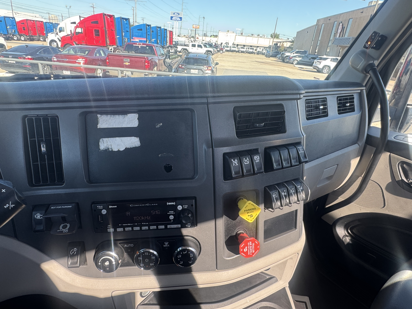 Truck cab dashboard interior showing control switches, air vents, and ignition area in a Peterbilt 579 day cab.