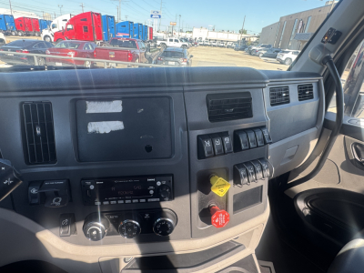 Truck cab dashboard interior showing control switches, air vents, and ignition area in a Peterbilt 579 day cab.